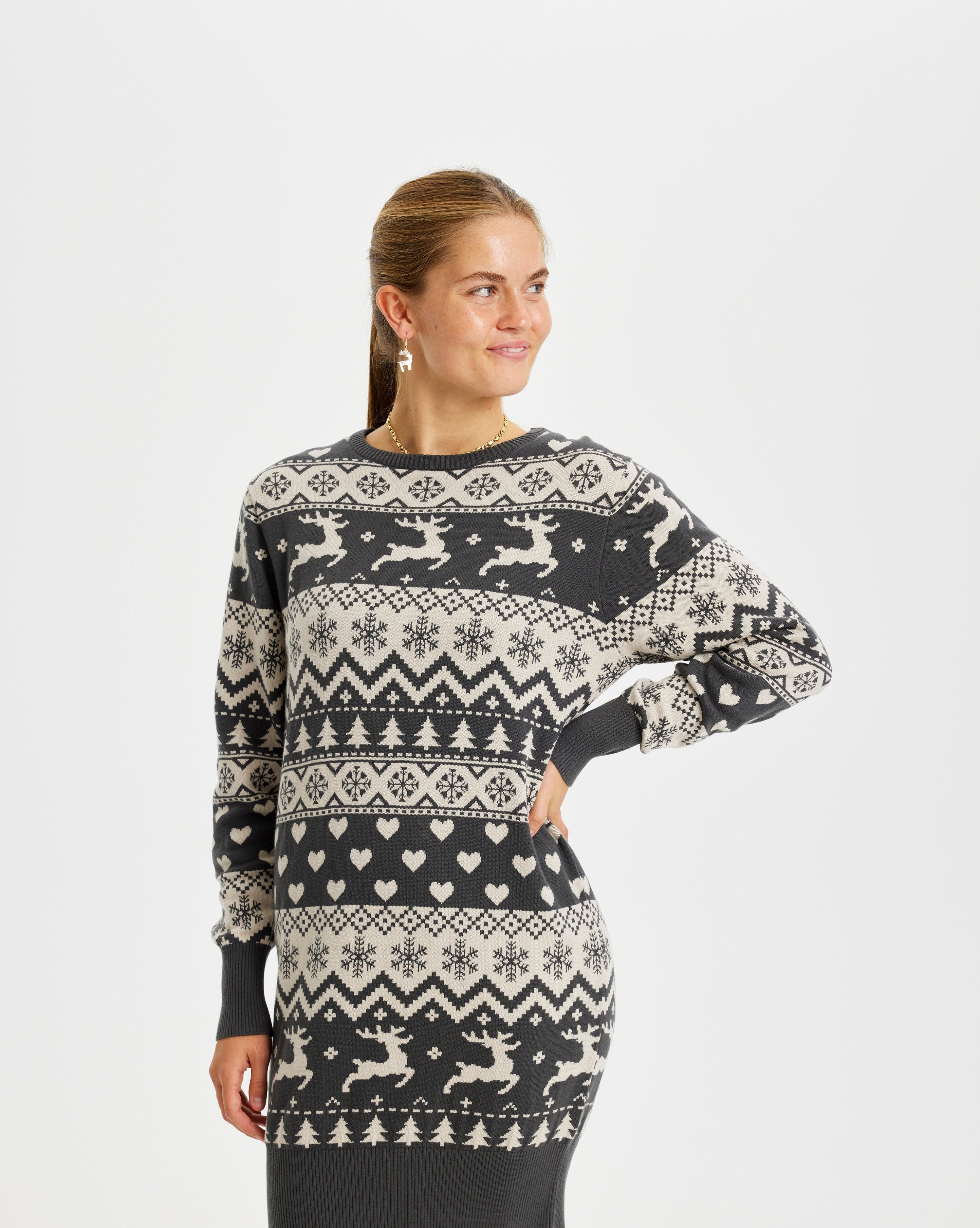 Eine Frau trägt ein graues Weihnachtskleid mit Rentieren darauf.